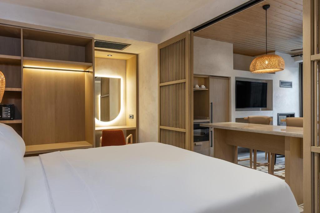 a hotel room with a white bed and a kitchen at Radisson Blu Hotel, Kas in Kaş