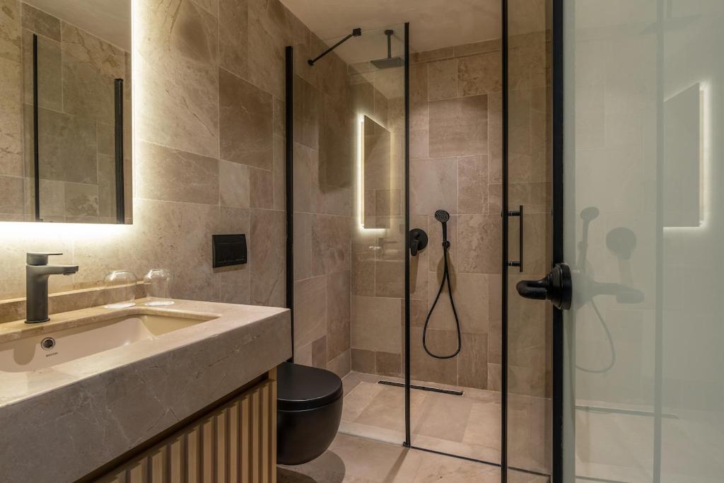 a bathroom with a shower with a sink and a toilet at Radisson Blu Hotel, Kas in Kaş