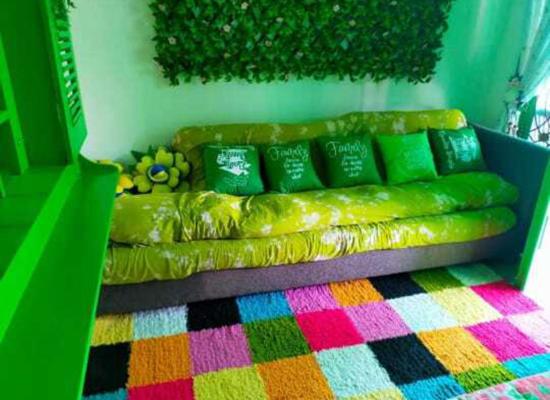 a green couch in a room with a colorful rug at GS Homestay Banyuwangi in Banyuwangi