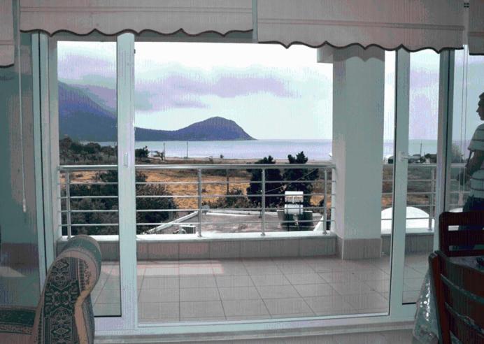 a room with a view of the ocean from a balcony at Ezgi Apart in Karaoz