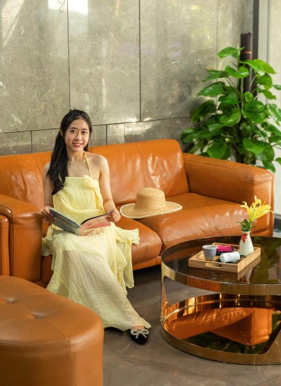 A leather seating nook in the hotel lobby with a guest reading beside a coffee table.