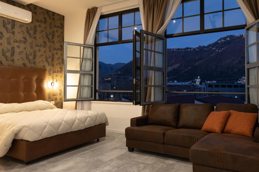 コモにあるLiving Lake Como-Rooms&Parkingのベッドとソファと窓のある寝室