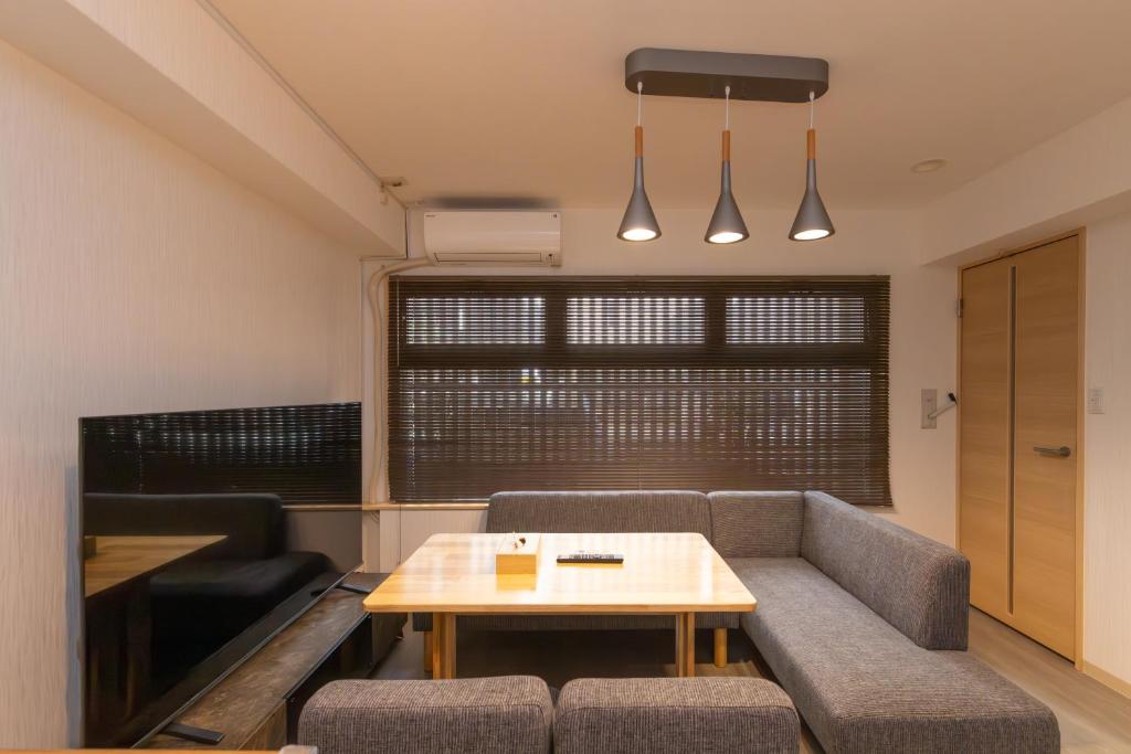ein Wohnzimmer mit Sofa und Tisch in der Unterkunft Ocean Nipponbashi Higashi in Osaka