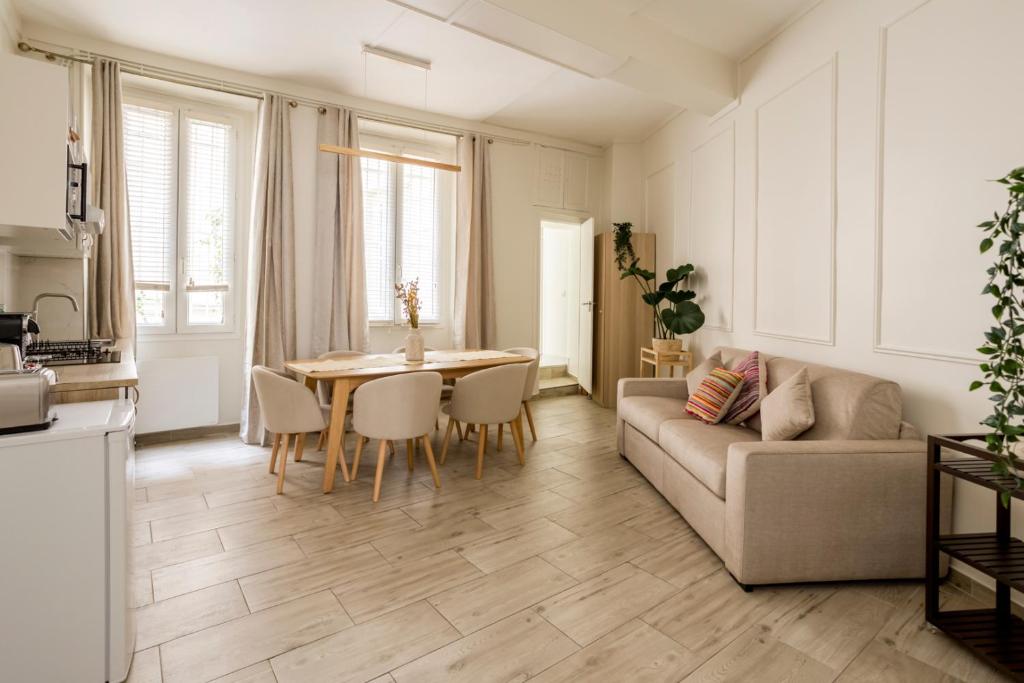 un salon avec un canapé et une table dans l'établissement Reva Suites, à Paris