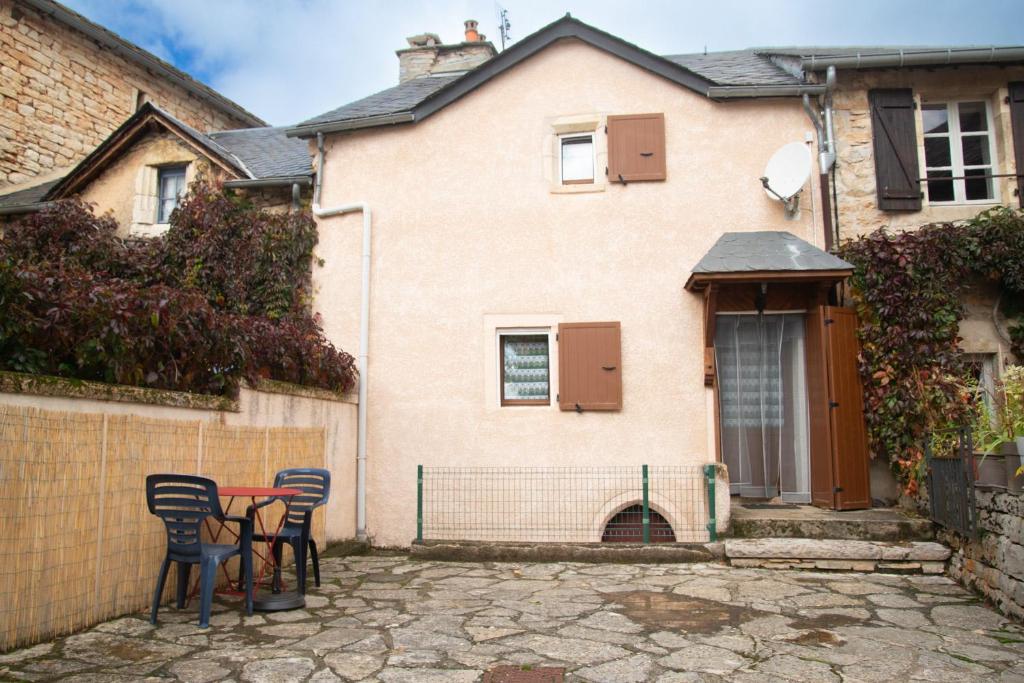 une table et des chaises devant une maison dans l'établissement Le castel, à Laval-du-Tarn