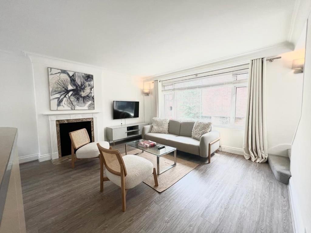 a living room with a couch and a fireplace at Split Level 2 Bed Apartment- Mayfair in London