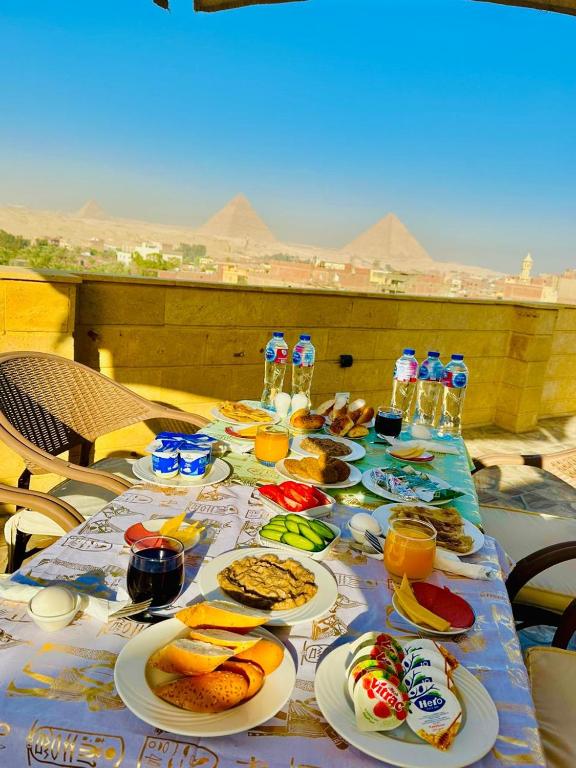 stół z talerzami jedzenia i napojów w obiekcie Hapi Pyramids Hotel w Kairze
