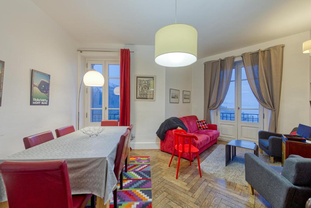 un salon avec une table et un canapé rouge dans l'établissement Snow Tram - Proche piste et thermes, à Saint-Gervais-les-Bains