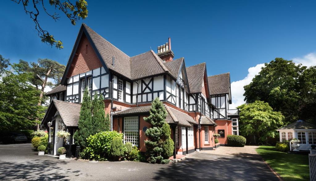 a large house with a black and white building at Langtry Manor Hotel in Bournemouth