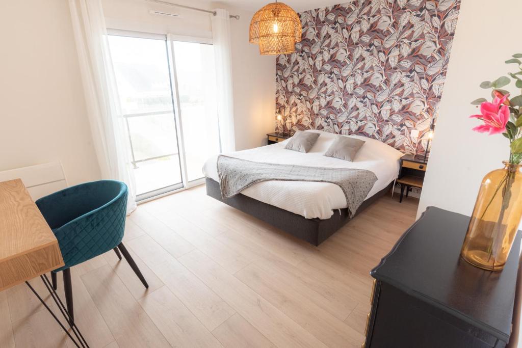 a bedroom with a bed and a vase of flowers at Elégant Appartement 2 chambres bord de mer par Groom in Ploemeur