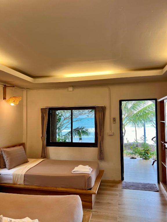 ein Schlafzimmer mit zwei Betten und einem Fenster in der Unterkunft Pen's Bungalow Koh Phangan in Thong Nai Pan Yai