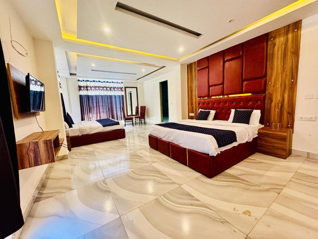 una camera da letto con un letto e una televisione di The Royal Residence Inn a Manāli
