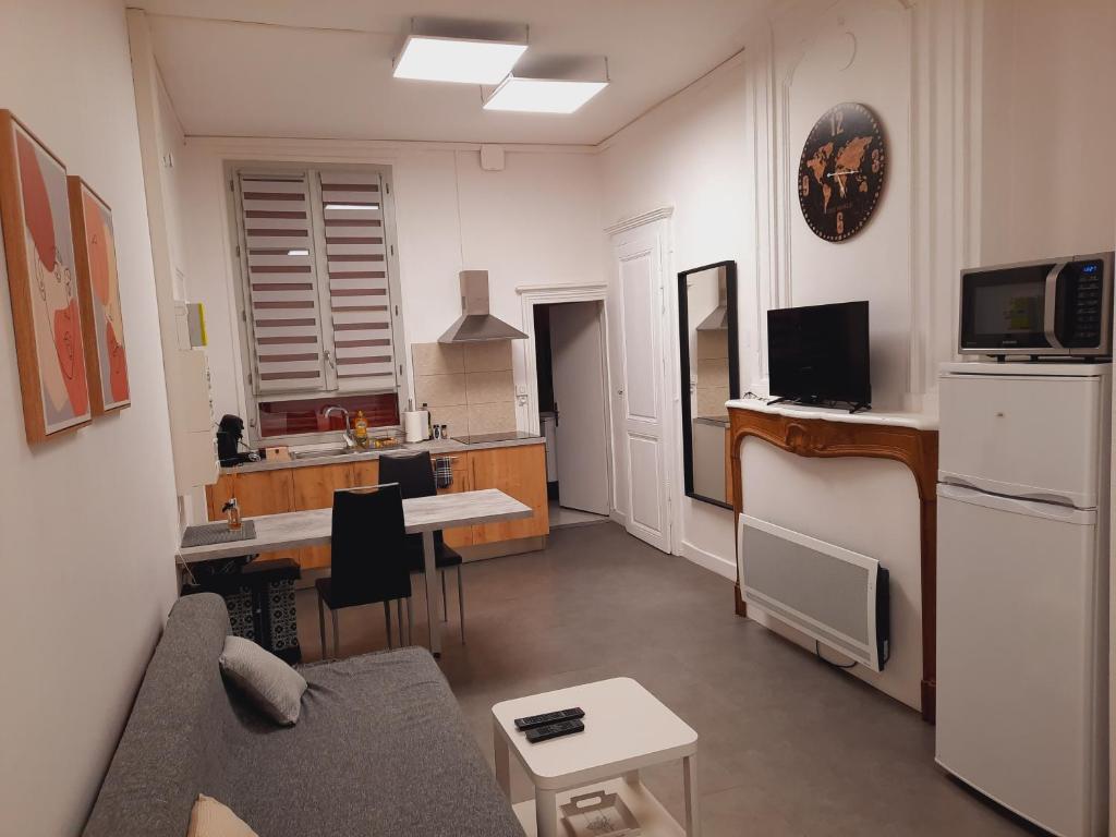 Una sala de estar con un sofá y una cocina. en Grand studio au calme - Dijon centre, en Dijon