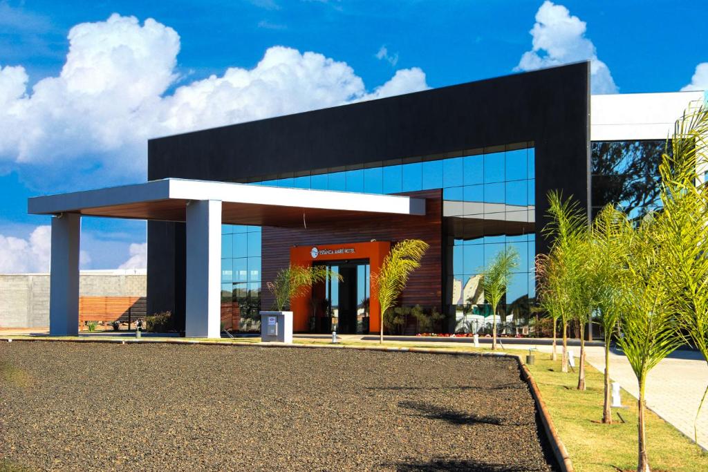 a black and white building with palm trees in front at Estância Avaré Hotel in Avaré