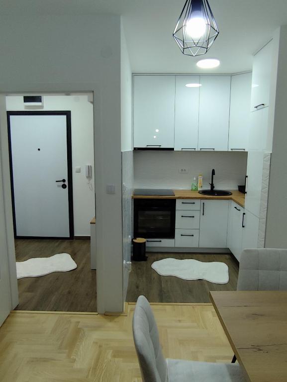 a kitchen with white cabinets and a table and a chair at Stan na dan Lane Pale in Pale