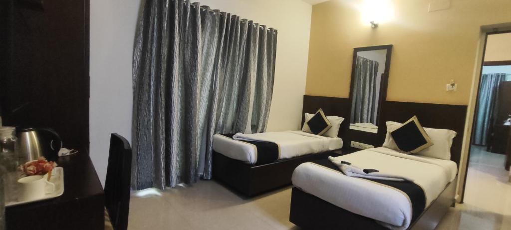 Postel nebo postele na pokoji v ubytování SKY GATE HOTEL Near Apollo MAIN, Women's & Children's US Consulate Sankara Netralaya Goethe Institute PrestigePalladium Shastri Bhavan Senmozhi Poonga Raj Ratnam Stadium TAJ Coromandal India Oil Bhavan Dr Mohan's Diabetics VAC Chennai