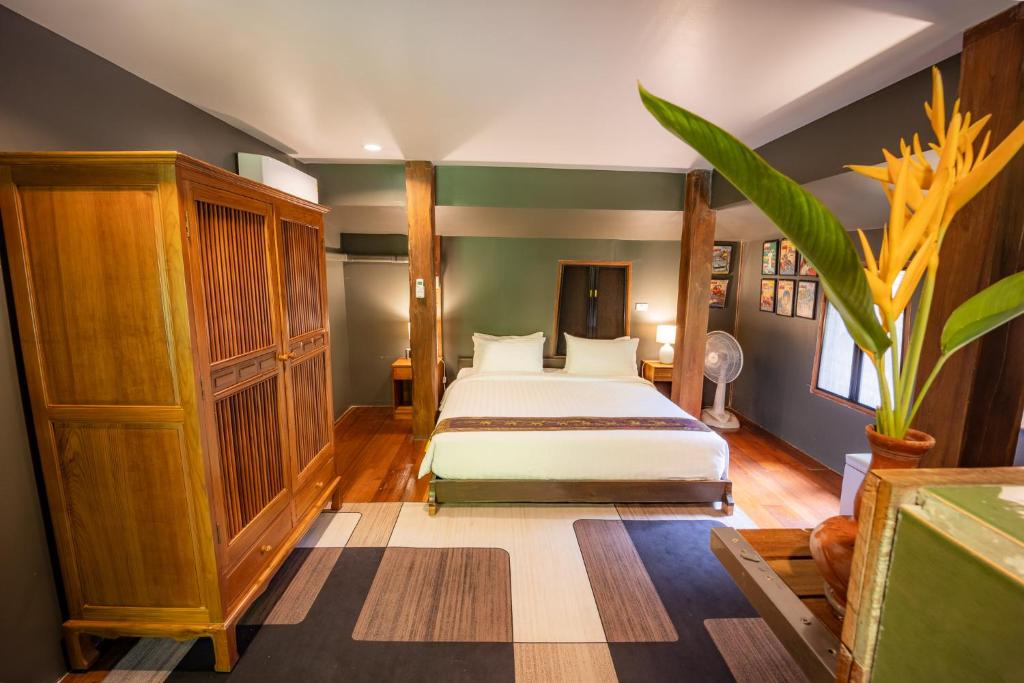 a bedroom with a bed and a plant at 11 Rooms in Chiang Dao