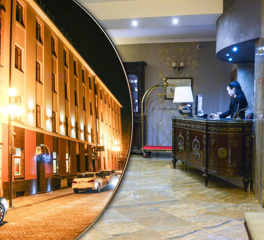 a mirror reflection of a room with a woman sitting at a desk at Komoda Club Residence in Kalisz