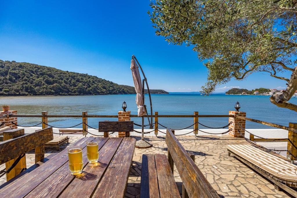 a picnic table with an umbrella and a view of the water at Apartments Emily in Kampor