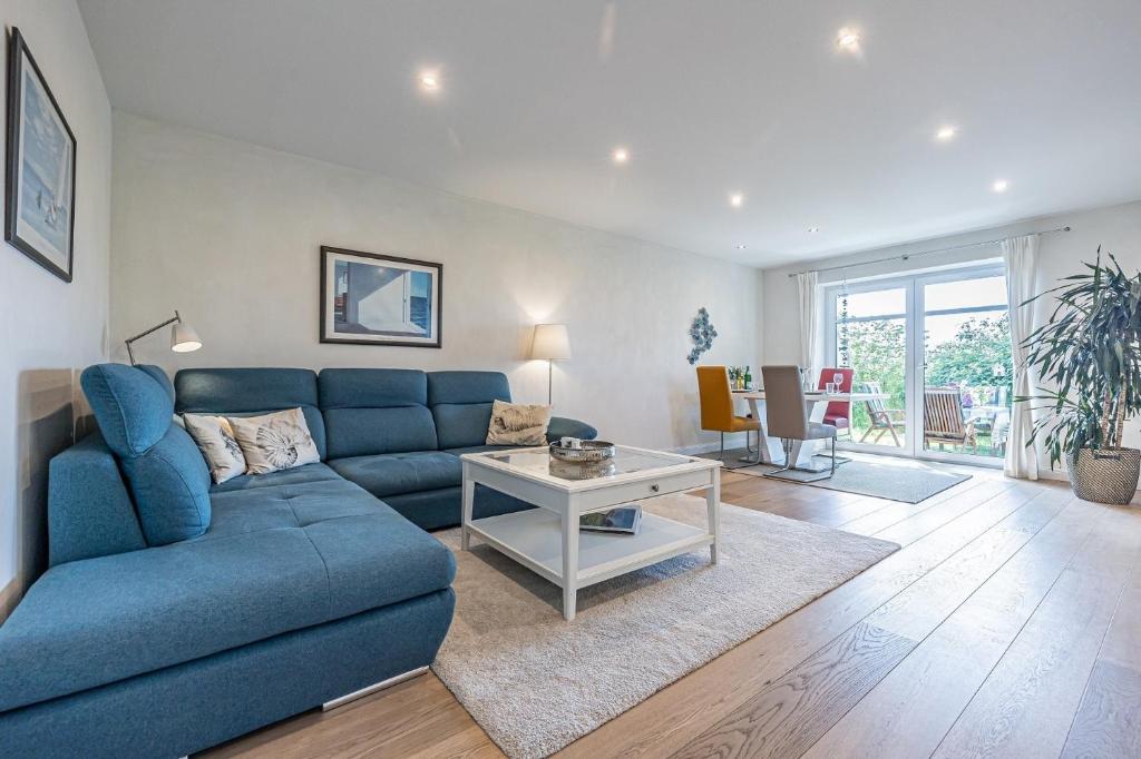 un soggiorno con un divano blu e un tavolo di Ferienwohnung Luv a Gelting