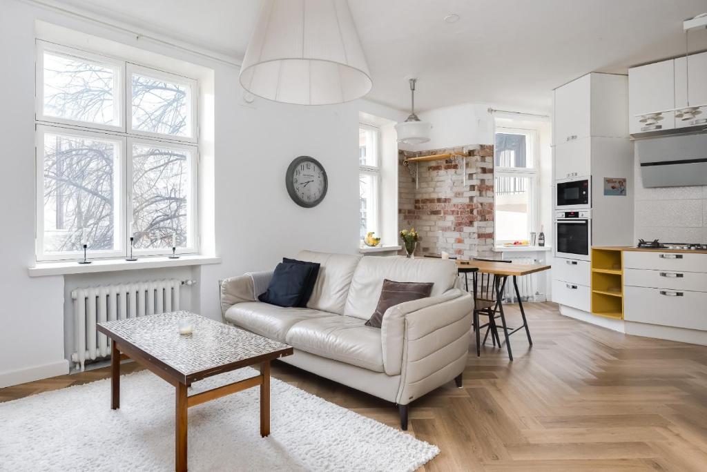 ヘルシンキにあるSTAY Kamppi Seaside Apartmentのソファとテーブルのある白いリビングルーム