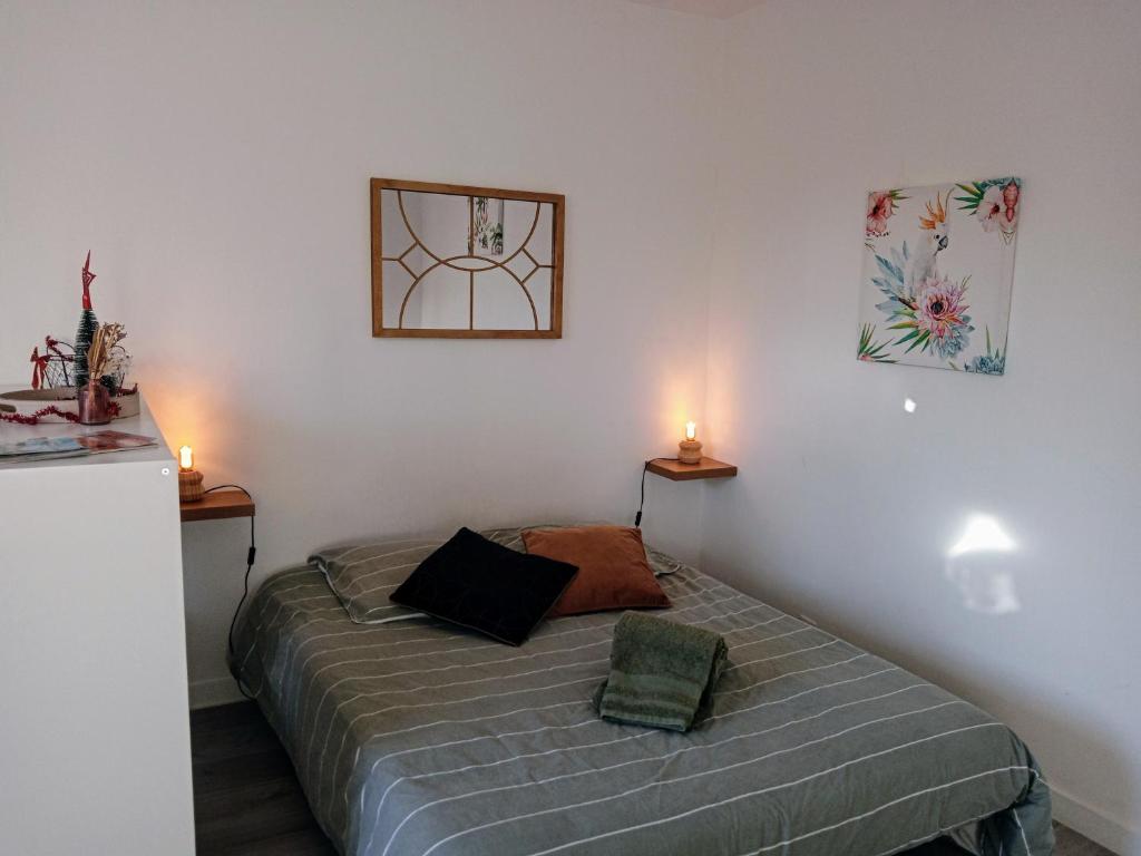 une chambre avec un lit avec deux bougies dessus dans l'établissement L'Urban centre ville linge café thé inclus, à Vannes