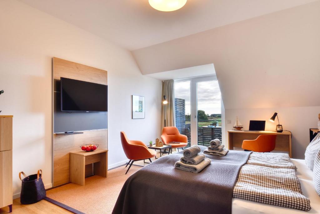 a hotel room with a bed and a large window at Ferienwohnung Grasmücke 09 im Wreecher Idyll Rügen by ruyastay in Putbus