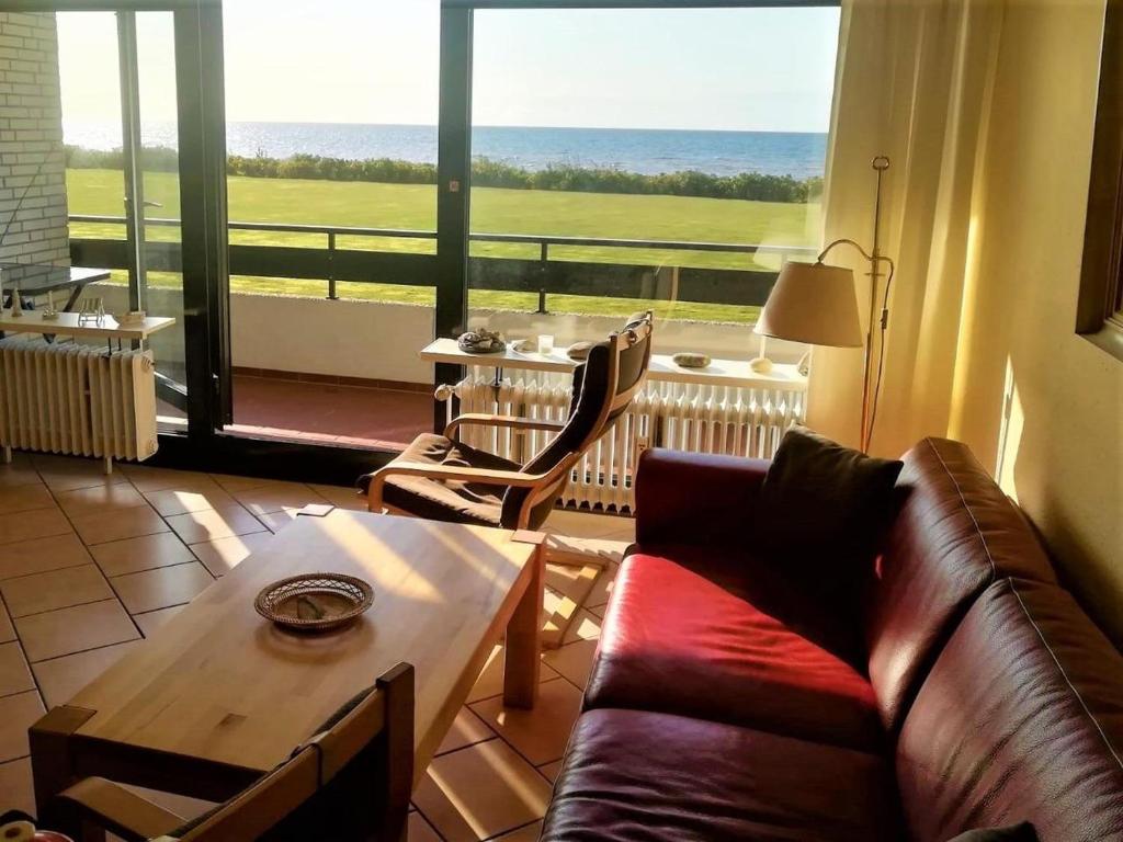 a living room with a couch and a table and a large window at FeWo Schulze in Fehmarn