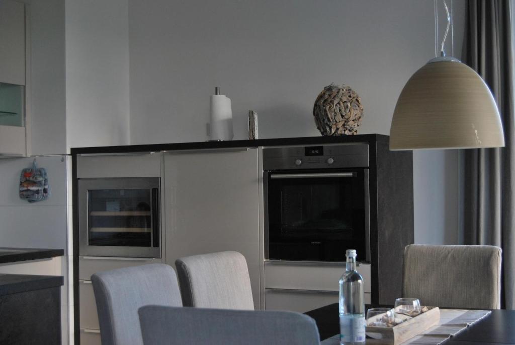 une cuisine avec une table et des chaises ainsi qu'une télévision dans l'établissement Ferienresidenz Haus Vogelflug Strandresidenz Vogelflug App 10, à Fehmarn