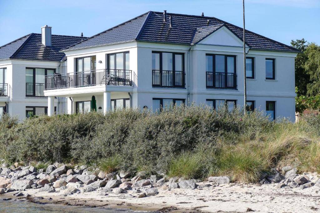 a large white house on the shore of the water at Ferienresidenz Haus Vogelflug Strandresidenz Vogelflug App 18 in Fehmarn
