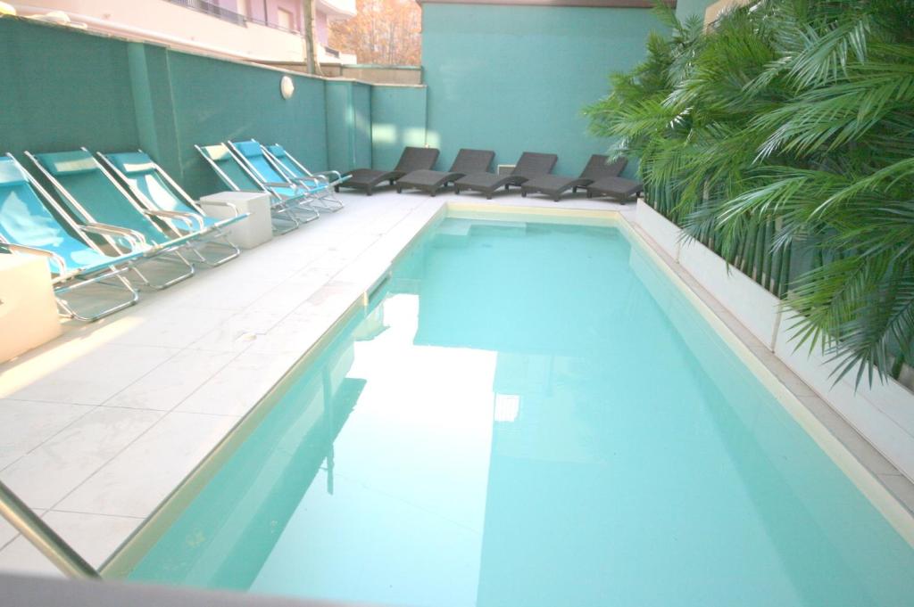 a large swimming pool with chairs in a building at Residence Beach Paradise in Rimini