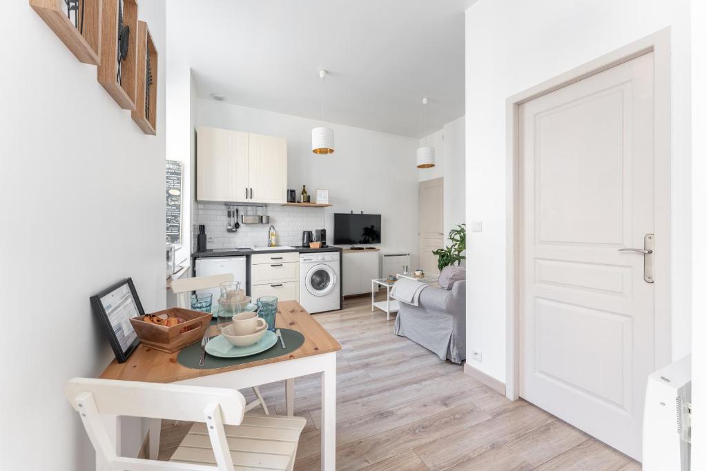 Il comprend un salon blanc avec une table et une cuisine. dans l'établissement Moma - Au cœur du quartier Vaise, à Lyon