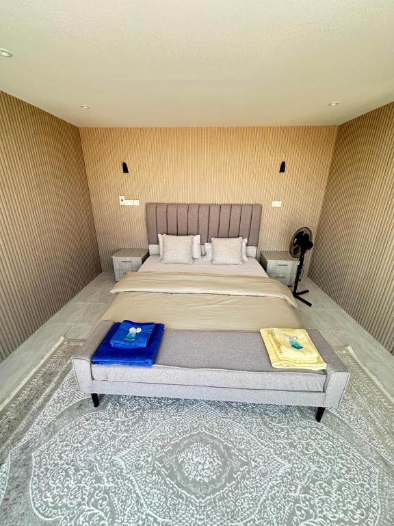 Al RakaにあるModern private bedouin campの青い毛布が掛けられた大きなベッドのある寝室