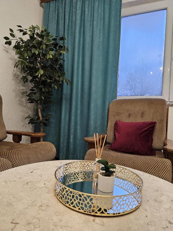 a living room with a table with a couch and a window at Amaya Home Sarajevo in Vogošća
