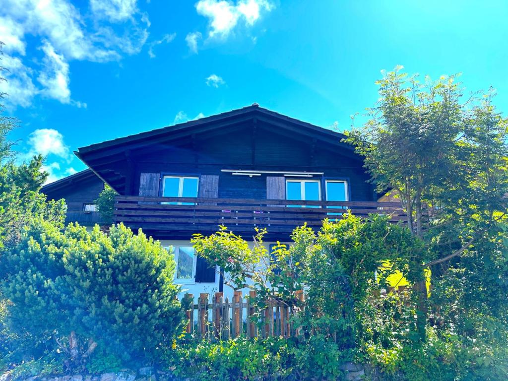 una casa in legno con una recinzione di fronte ad essa di SwissHut Stunning Views Alps - Chalet Flora a Beatenberg