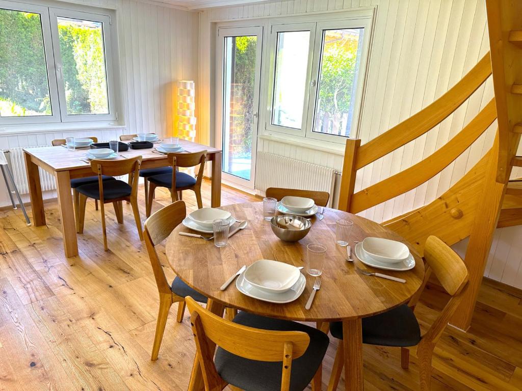 una sala da pranzo con tavoli, sedie e finestre di SwissHut Stunning Views Alps - Chalet Flora a Beatenberg