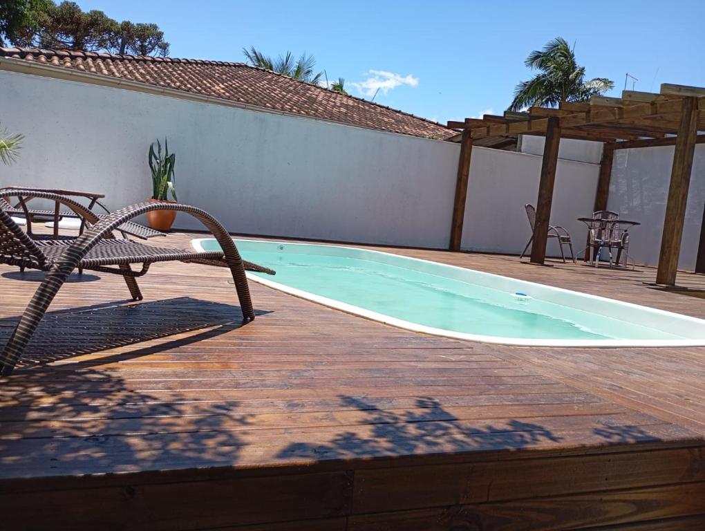 a swimming pool with a chair and a table at Departamento 3- Pinheira in Praia de Cima (Pinheira)