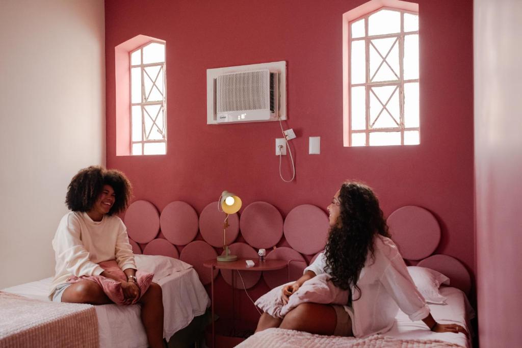 two women sitting on beds in a room at Chez Zany Boutique Hostel - Copacabana in Rio de Janeiro