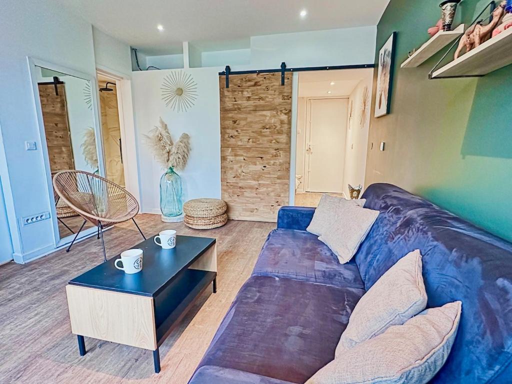 un salon avec un canapé bleu et une table dans l'établissement Modern Apartment & Parking, à Villeurbanne