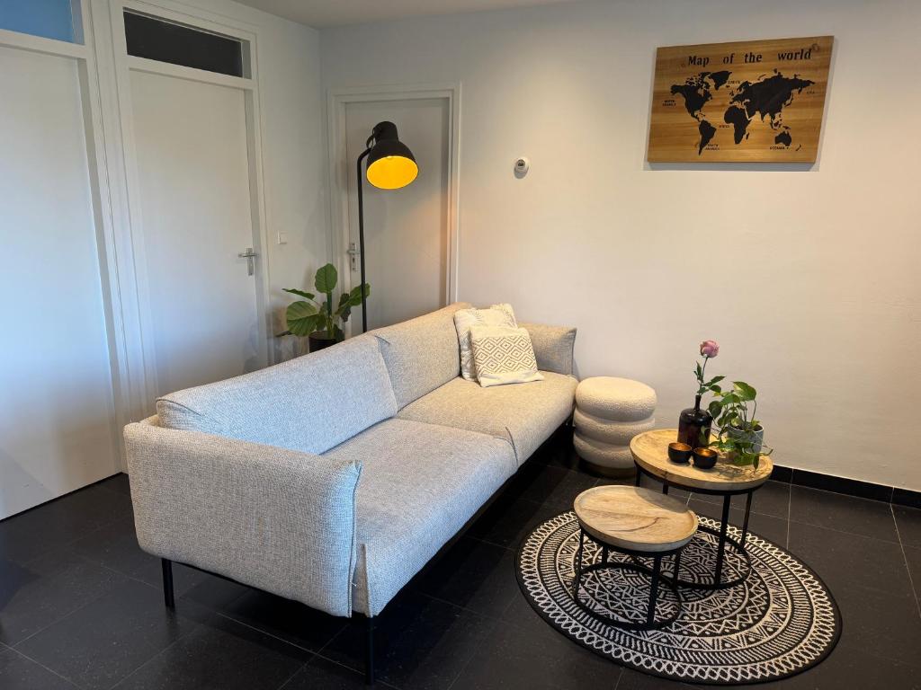 een woonkamer met een bank en een tafel bij Vakantiewoning aan de Kust 16 in Egmond aan Zee