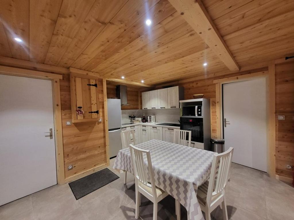 une cuisine avec une table et des chaises dans une pièce dans l'établissement Charmant appartement au calme avec wifi et cuisine équipée - FR-1-266-164, à Montgenèvre