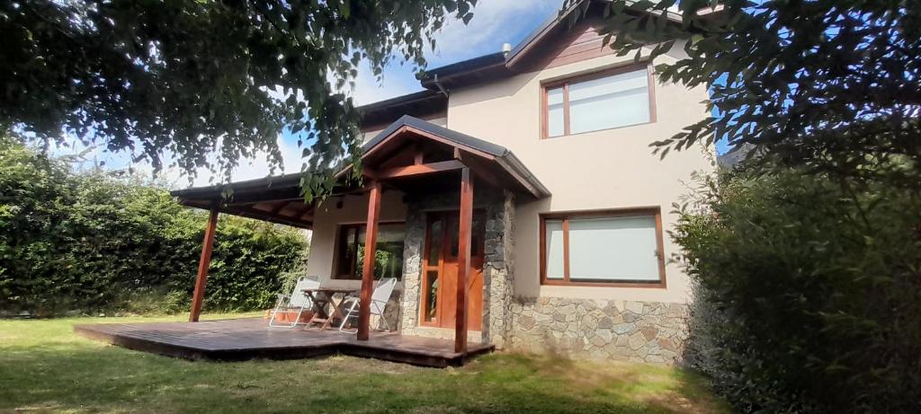 普埃洛湖Hostel La llegada的院子里有一栋带木制门廊的小房子。