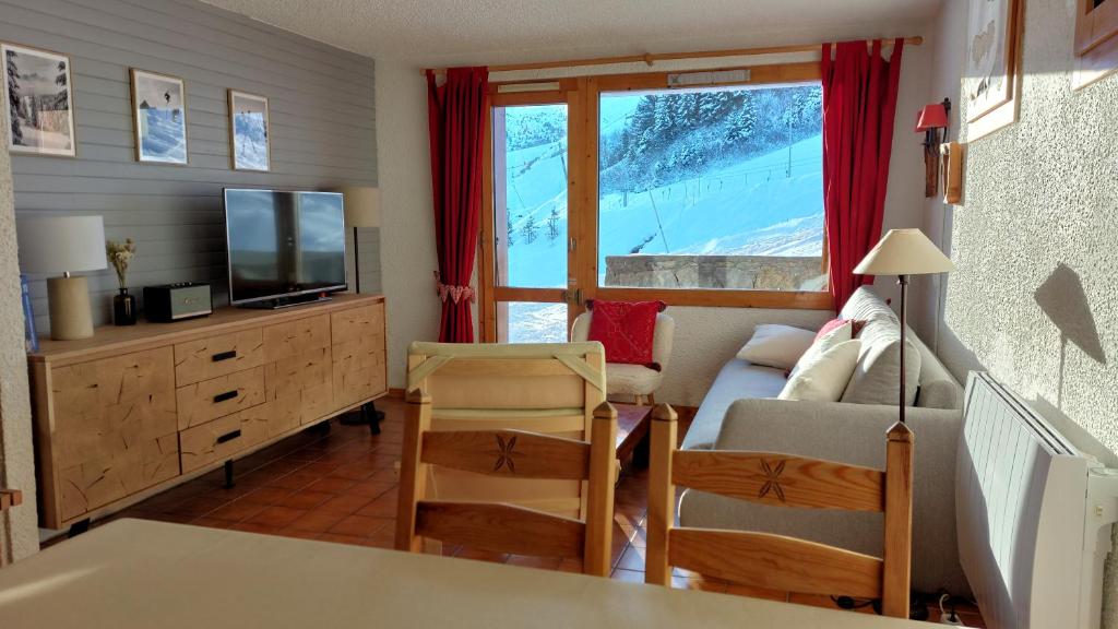 un salon avec un canapé et une télévision dans l'établissement Appartement skis aux pieds Méribel-Mottaret avec garage et wifi, à Méribel