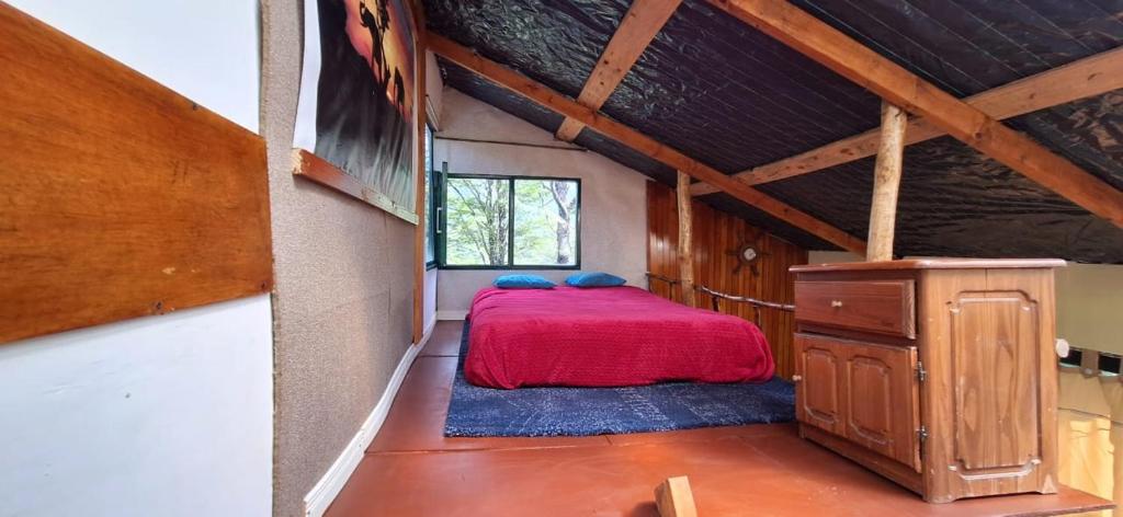 a bedroom with a red bed in a attic at El Isleño in Ushuaia