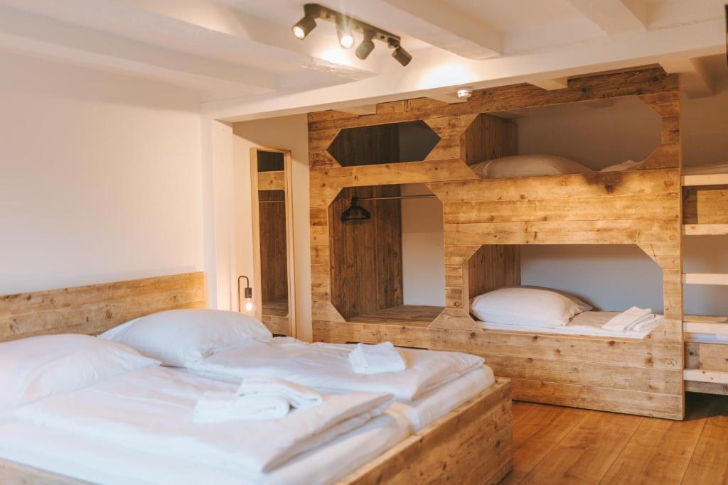 a bedroom with two beds and a wooden wall at Ferienhaus Waldtraum Winterberg in Winterberg