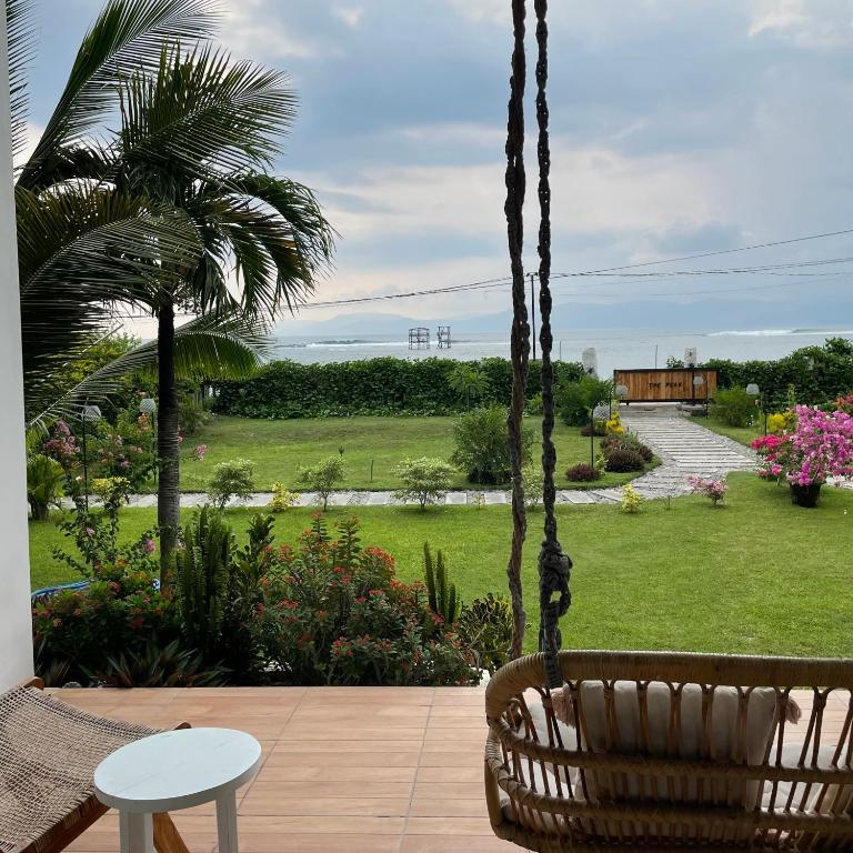 a porch swing with a view of a garden at The Peak Surf House in Huu
