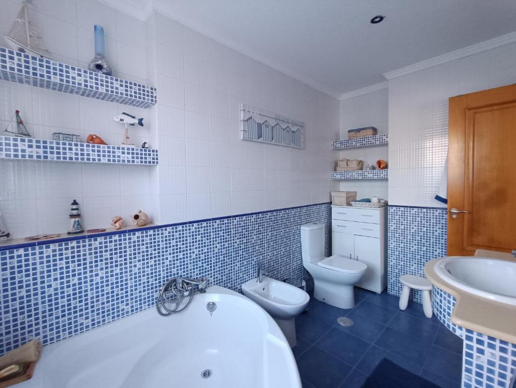 un bagno blu e bianco con vasca e servizi igienici di As Pagonas a Moaña