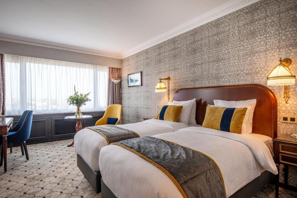 a hotel room with two beds and a table at Hotel Barsey by Warwick in Brussels