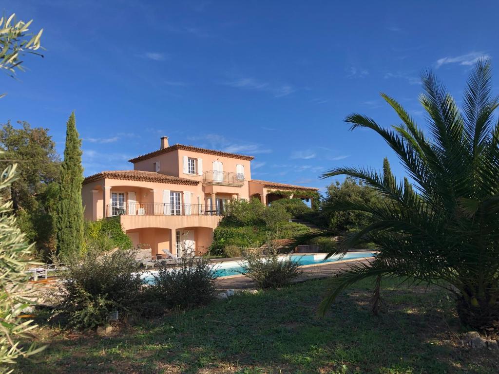 une grande maison avec une piscine devant dans l'établissement Villa Les Vignes, à Le Revest-les-Eaux