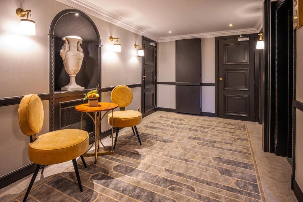 a corridor with chairs and a table and a door at Hotel Barsey by Warwick in Brussels